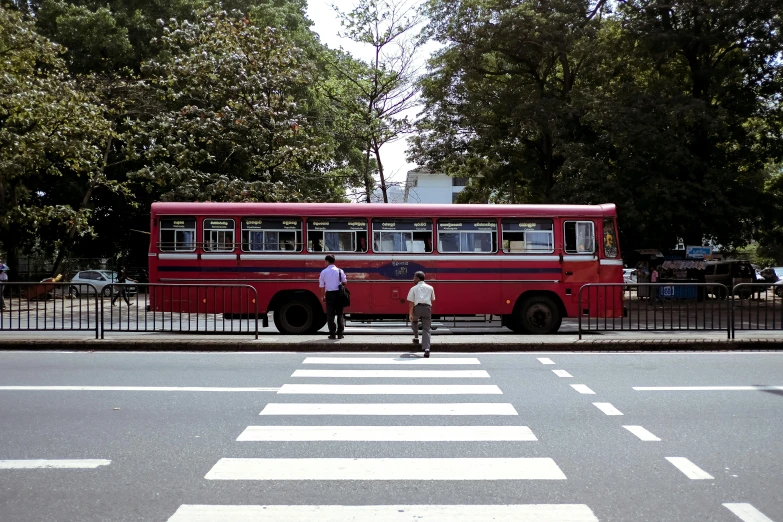 two people are standing in front of an old bus