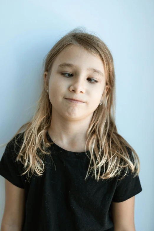 a little girl with long blond hair, wearing a black shirt