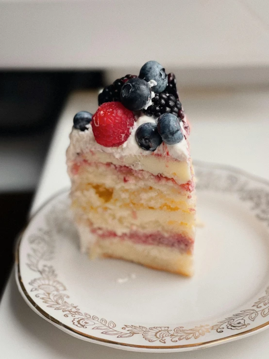 a piece of cake with fruit on top sits on a plate