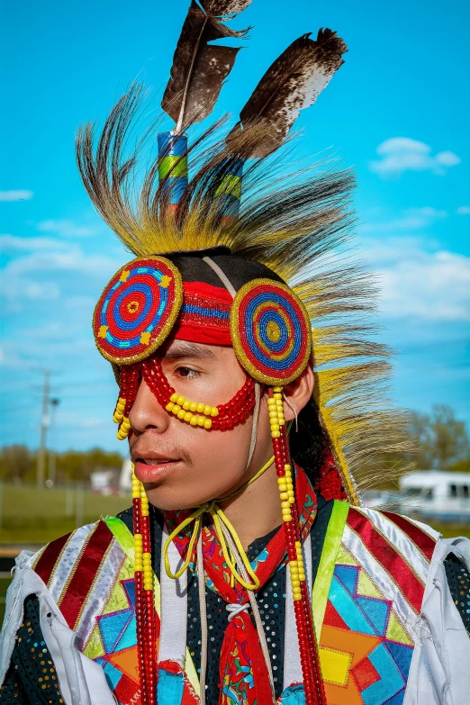 a person wearing feathers and an artistic costume
