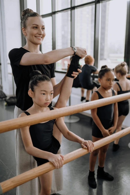 a woman is helping another woman fix her ballet leg