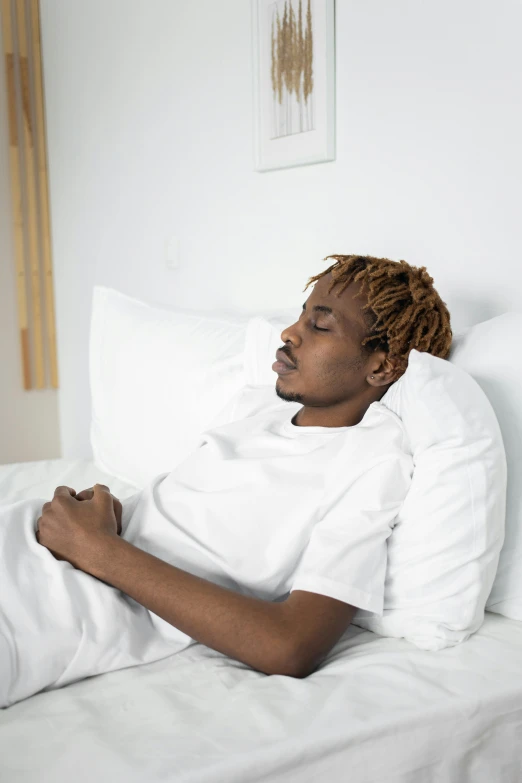 a black woman is asleep in her white bed