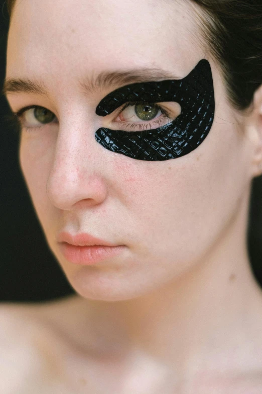 a woman with black eye patches on her face