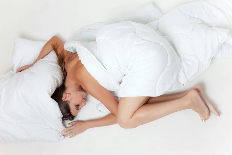 a woman laying in bed on a pillow