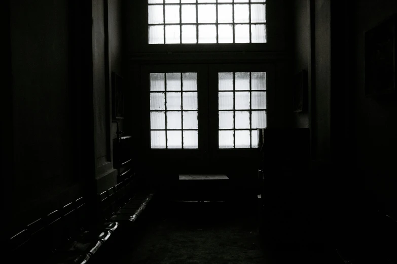 black and white po of a window with bars and a bench