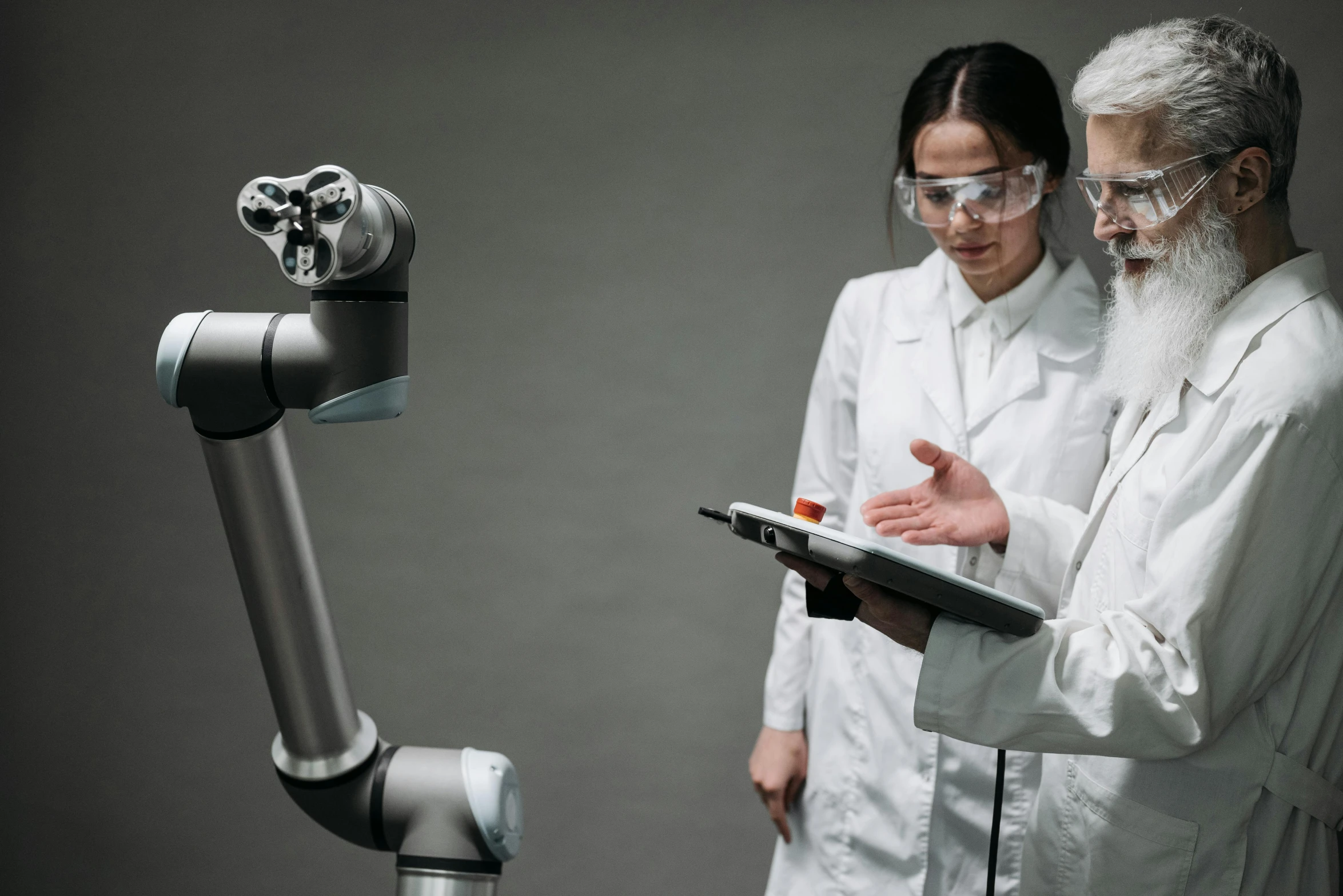 the robot is reading a book as it stands next to two men