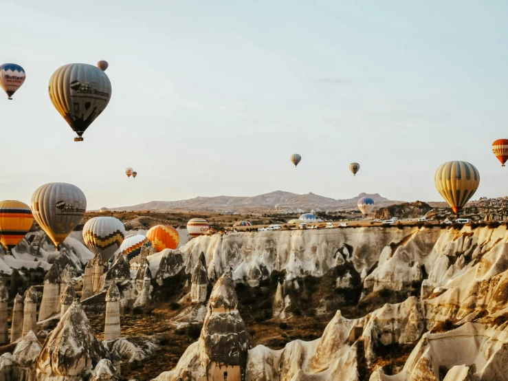 several colorful balloons flying over a rocky landscape