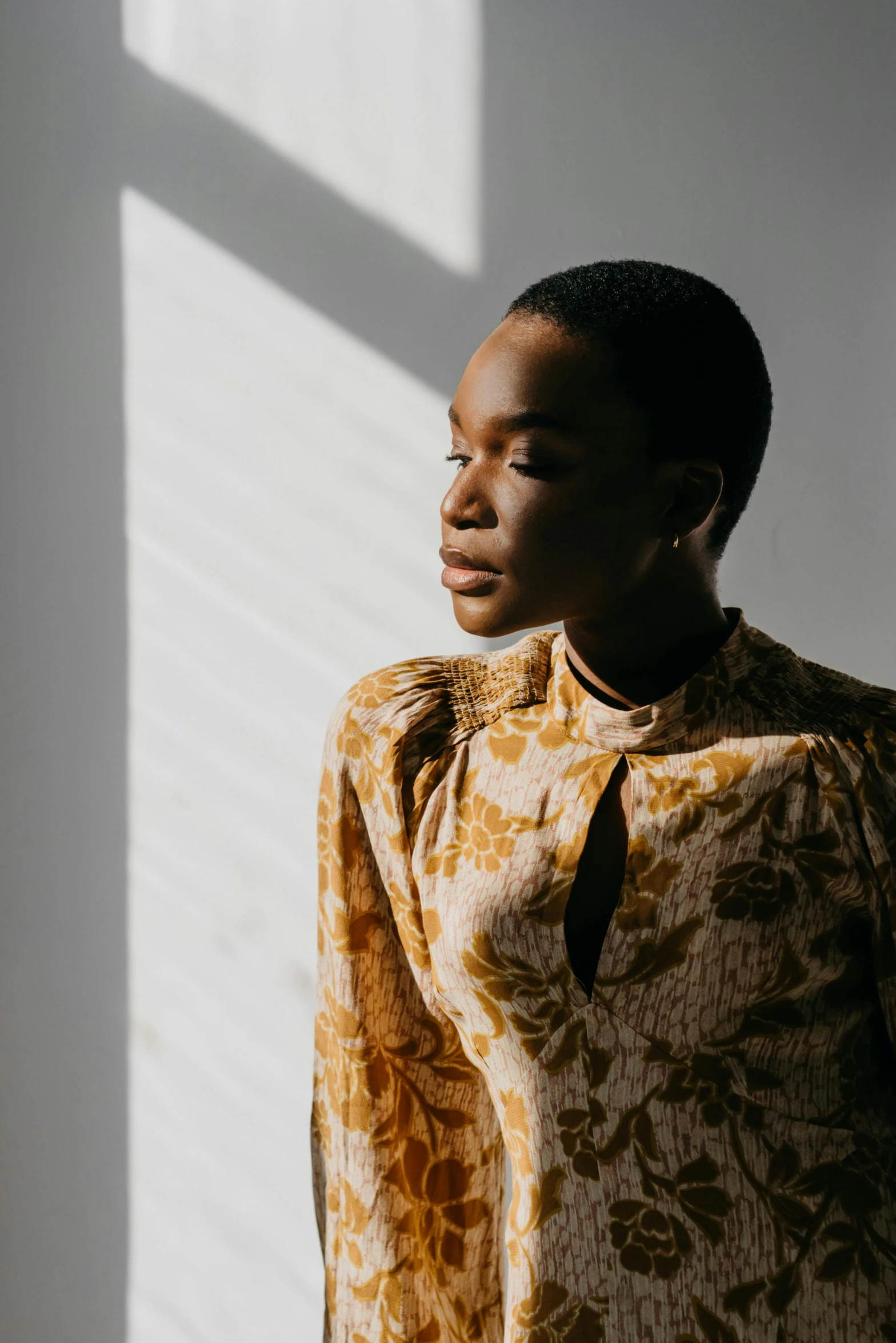 woman wearing long sleeve blouse next to white wall