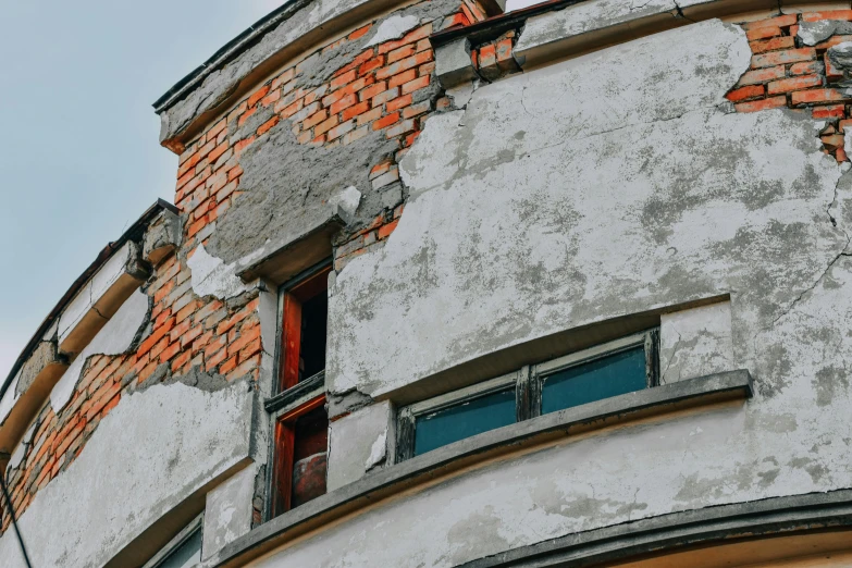 the corner of an old brick building shows an uneven facade