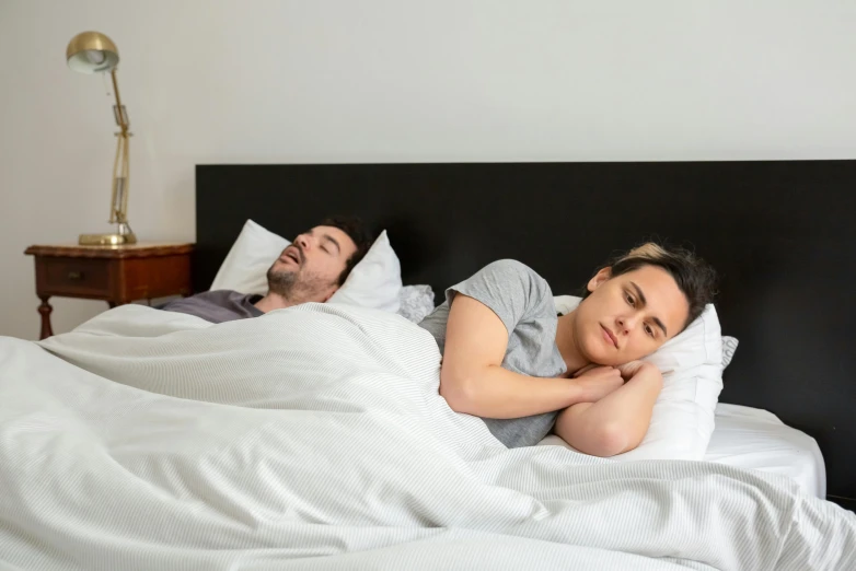 a man and woman are sleeping in bed