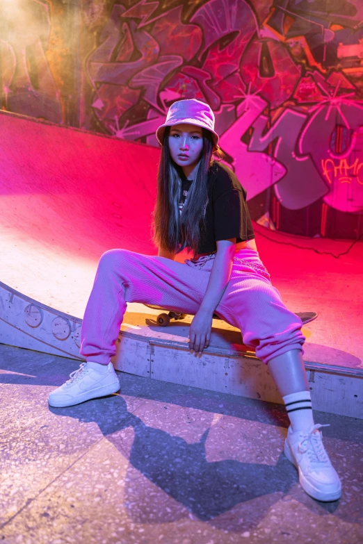 a girl sitting on a bench in front of a graffiti wall