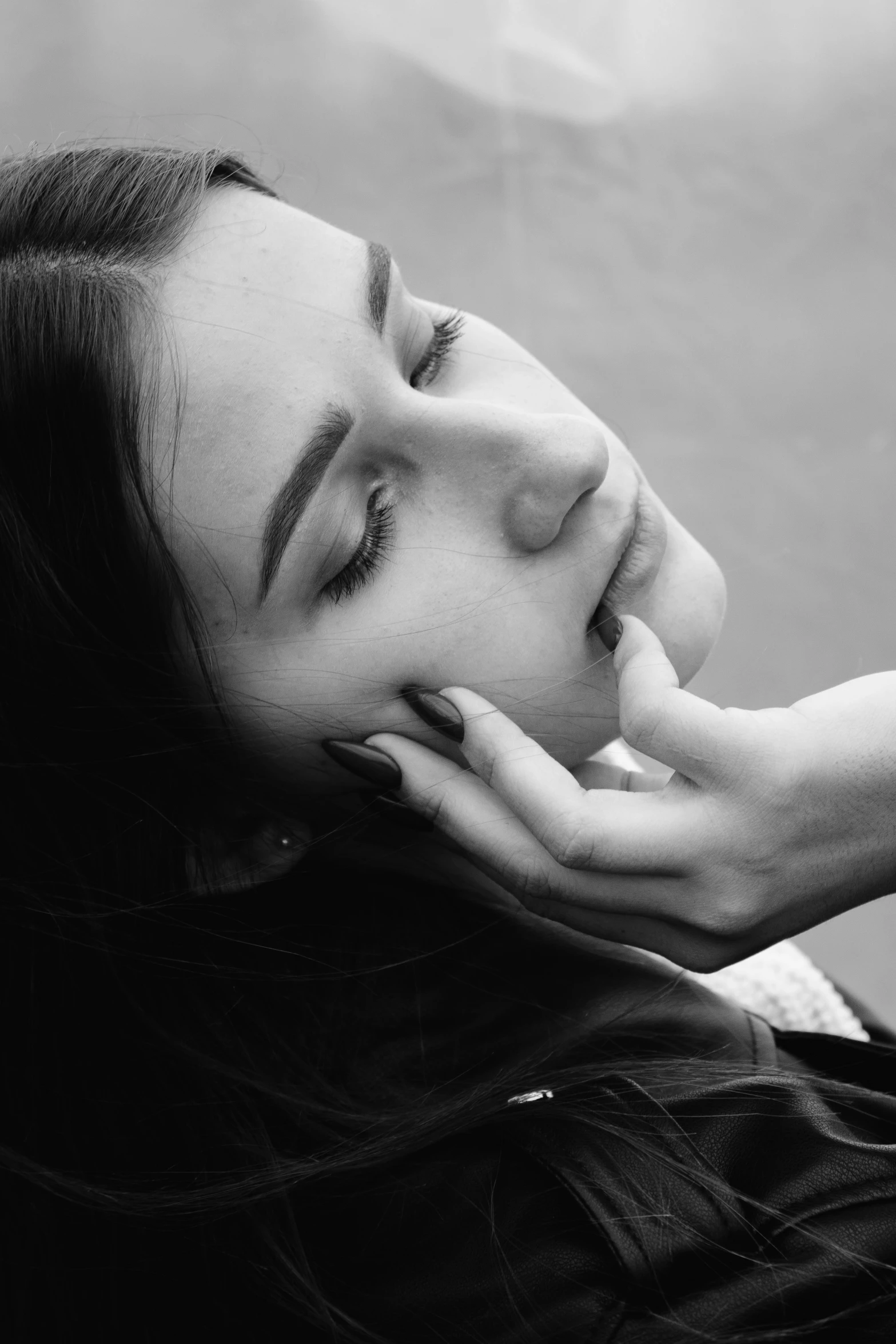 a black and white po of a woman laying her head on a railing