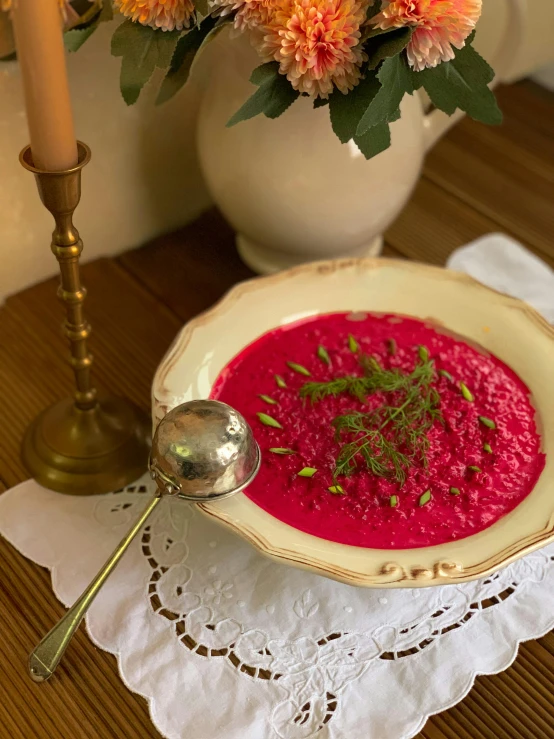 a bowl filled with soup next to some orange flowers