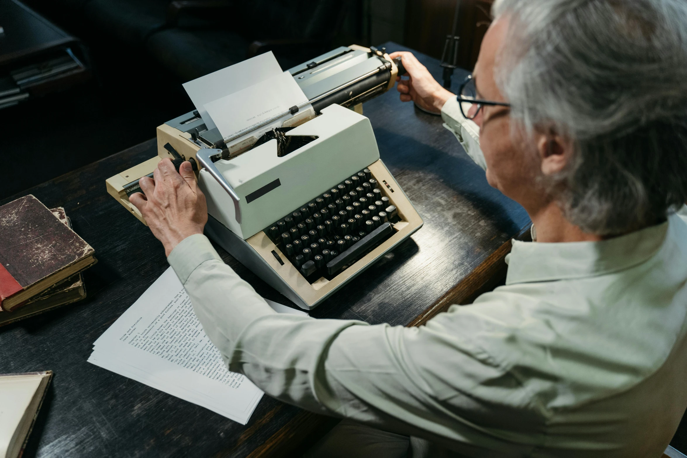 an old man is typing on a typewriter