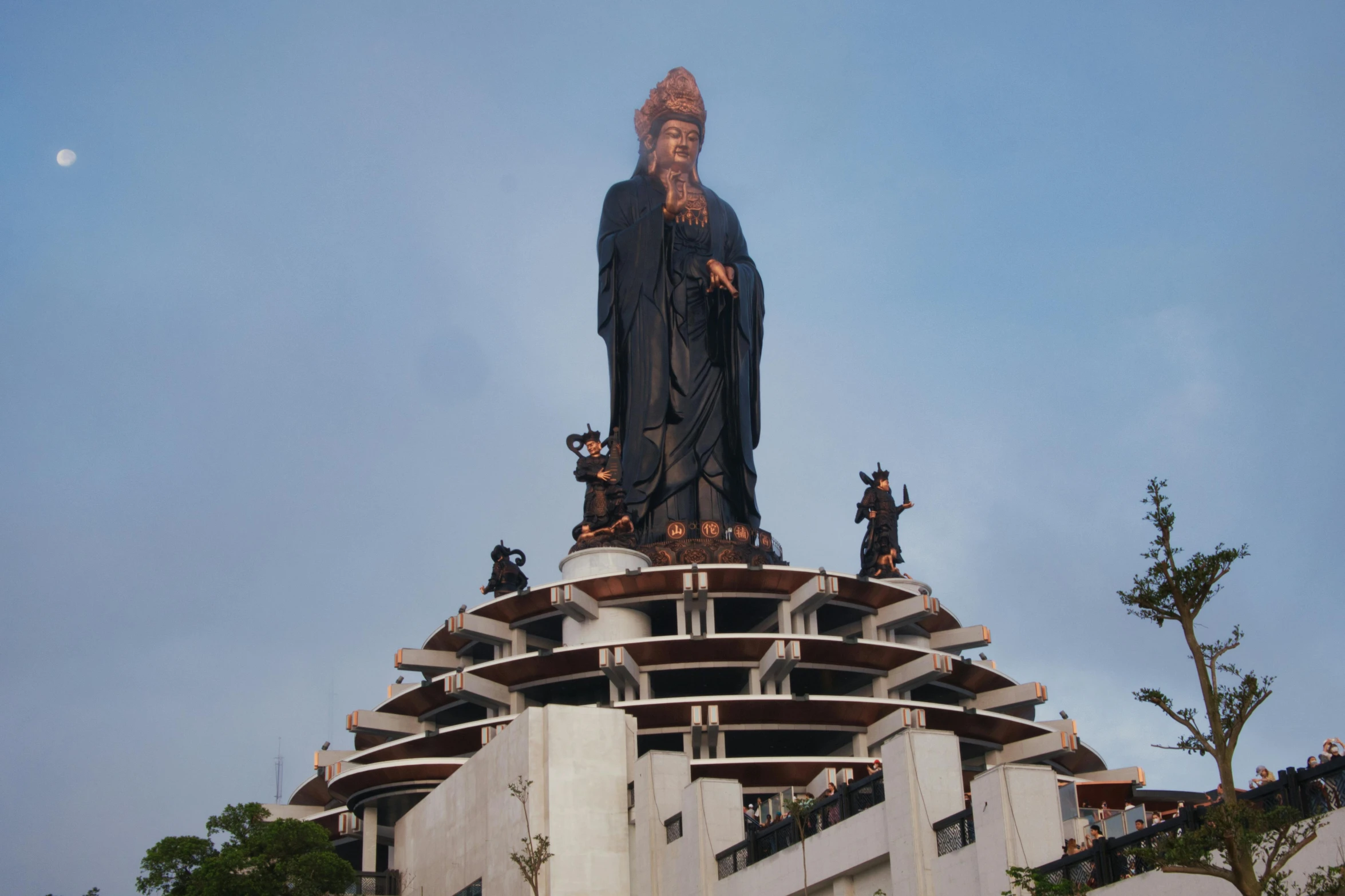 the large statue is positioned high on the roof