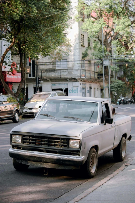 an old truck sitting on the side of a street