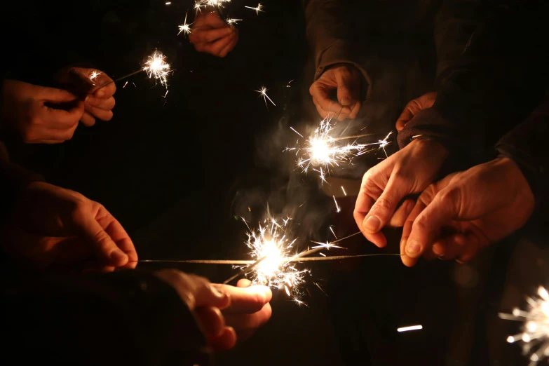 group of people holding sparklers while wearing suits and holding sparklers