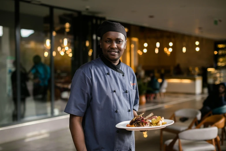 a chef in an elegant restaurant is holding a plate