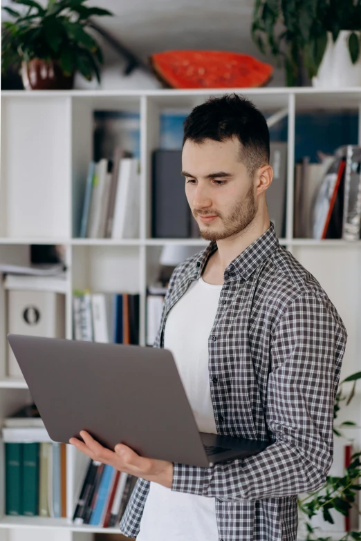 young man holding a laptop in his hands