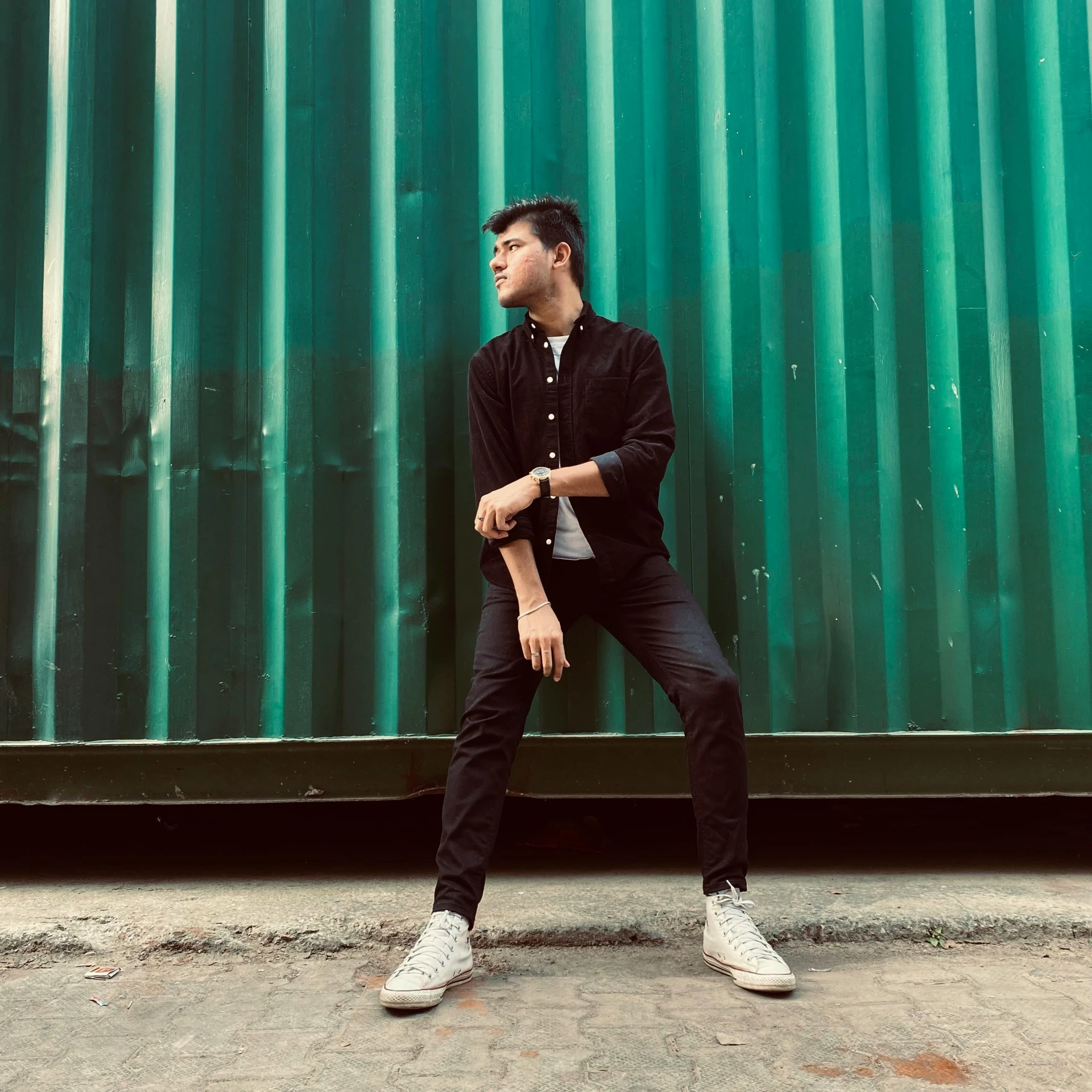 man leaning against metal wall on his knees