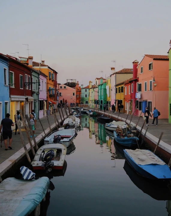 a narrow canal has many boats docked along it