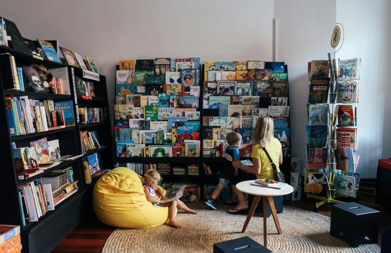 two children read books in a very well - lit room