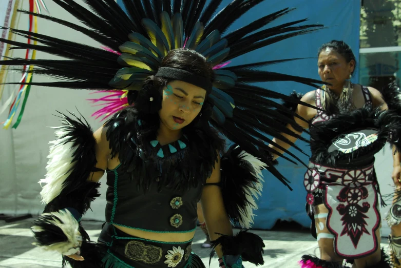 young women dressed in native attire walking on the side walk
