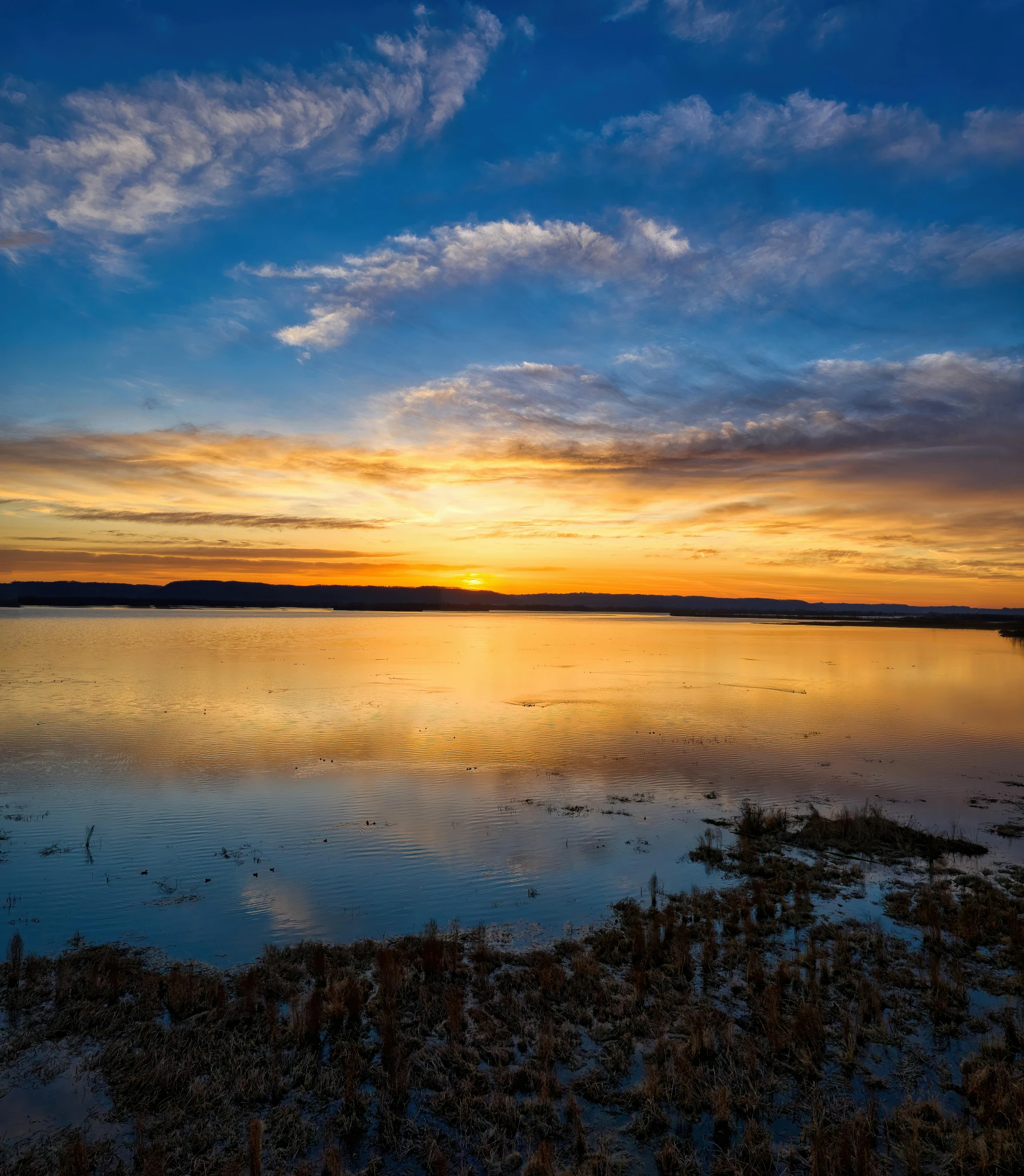 a sunset over a lake is shining in the distance