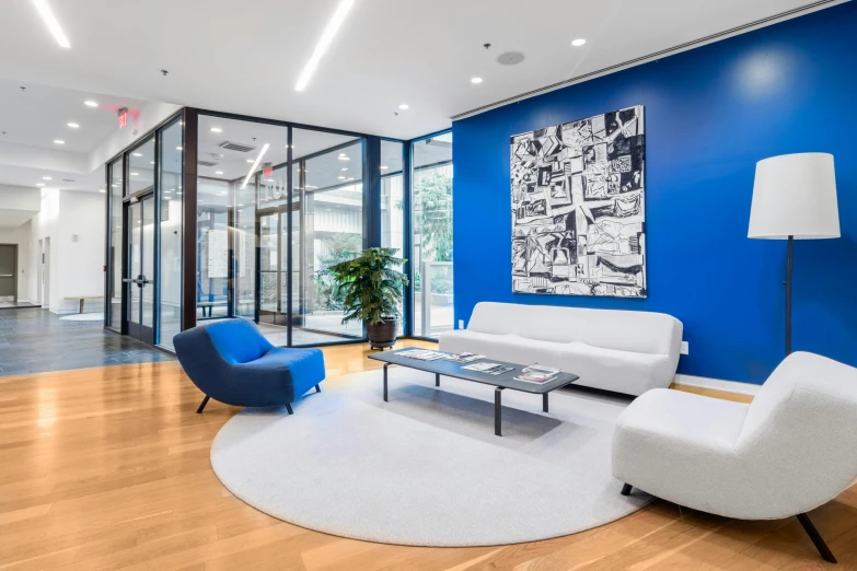 a room has blue walls and chairs and a coffee table