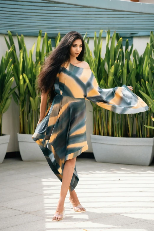 a woman walking down the runway carrying a dress