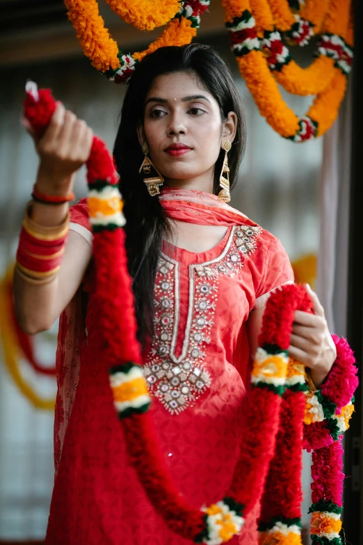 woman in red outfit hanging flower decorations