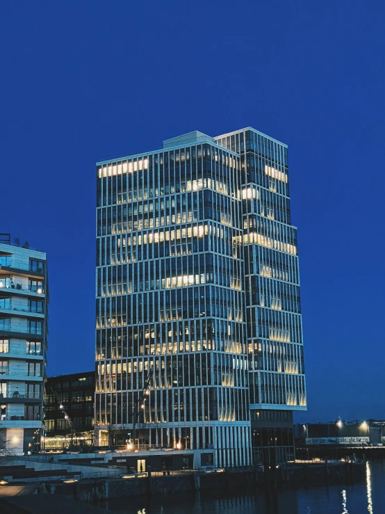 a building and some lights are lit up by the water