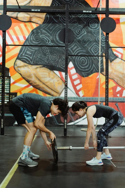 two men doing crossfit on an empty gym floor