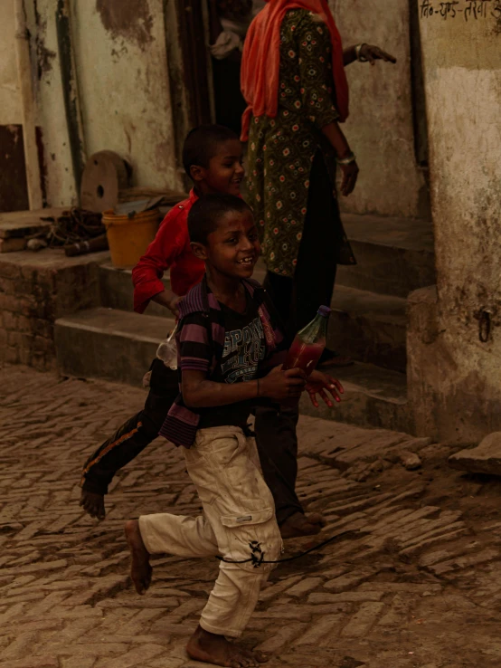 children playing on a cobble stone sidewalk