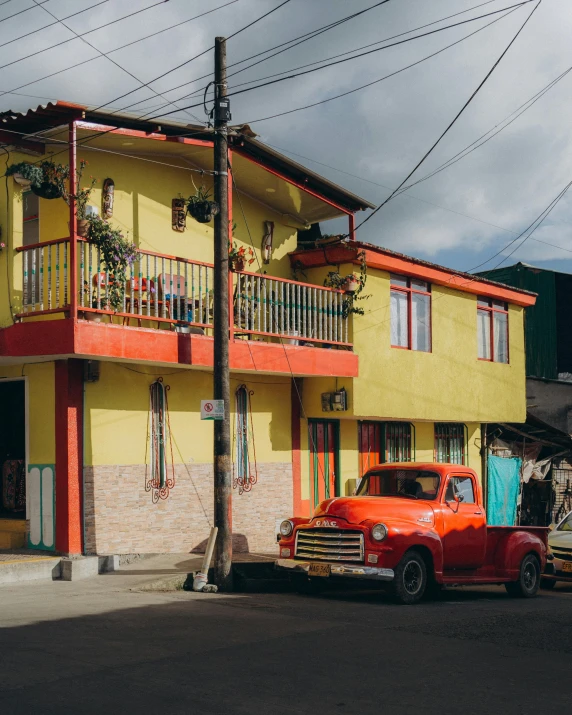 a truck parked next to a yellow and orange building