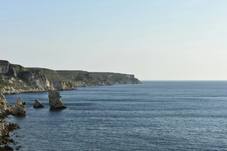 a scenic view of a cliff, water and trees