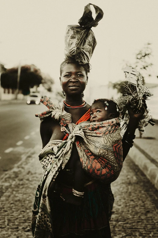 a woman with long hair carrying a baby in her arms