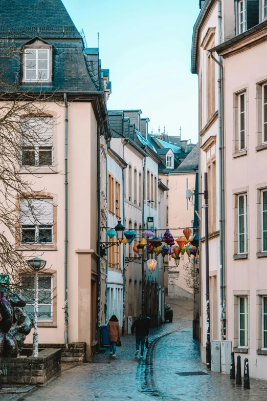 a cobbled sidewalk leading to two tall buildings