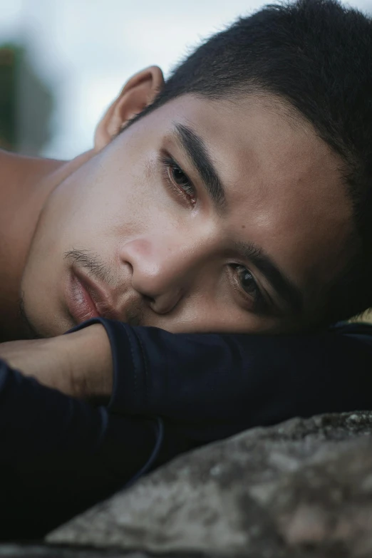 a man laying on top of a large rock