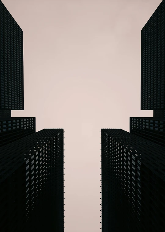 an upside down view of two black buildings