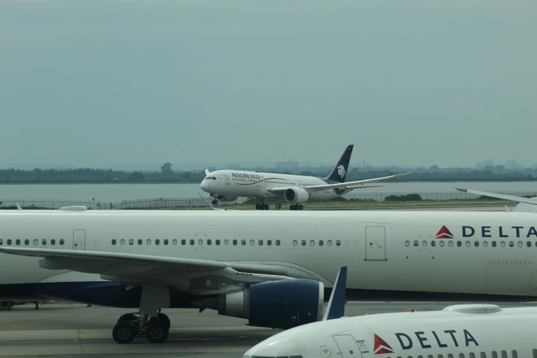 three white airplanes on the ground at an airport