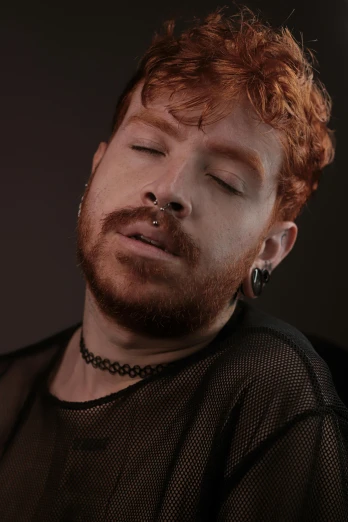 a man with red hair and beard wearing a necklace