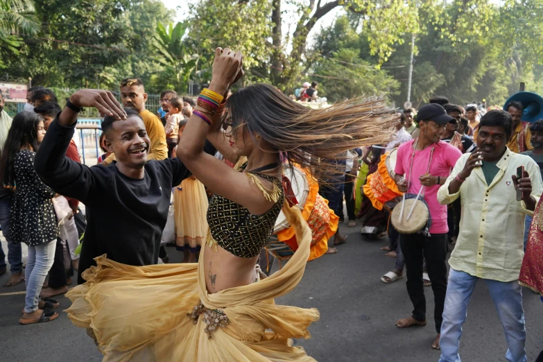 a couple of women dancing in a street while people watch