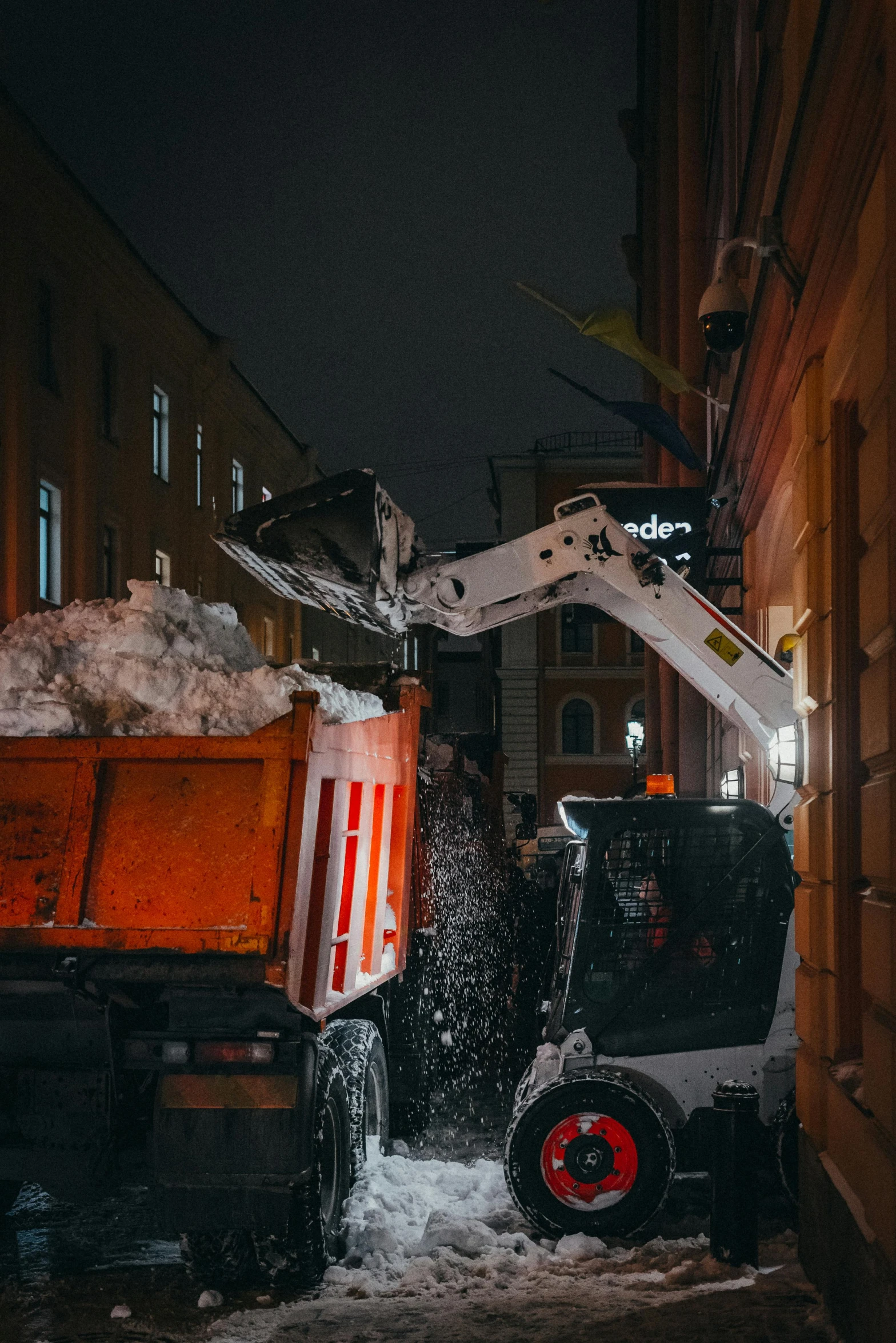 snow drifts from trucks parked on a snowy street