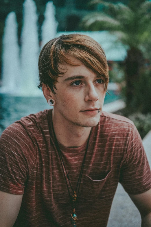 a man with long hair and a brown shirt