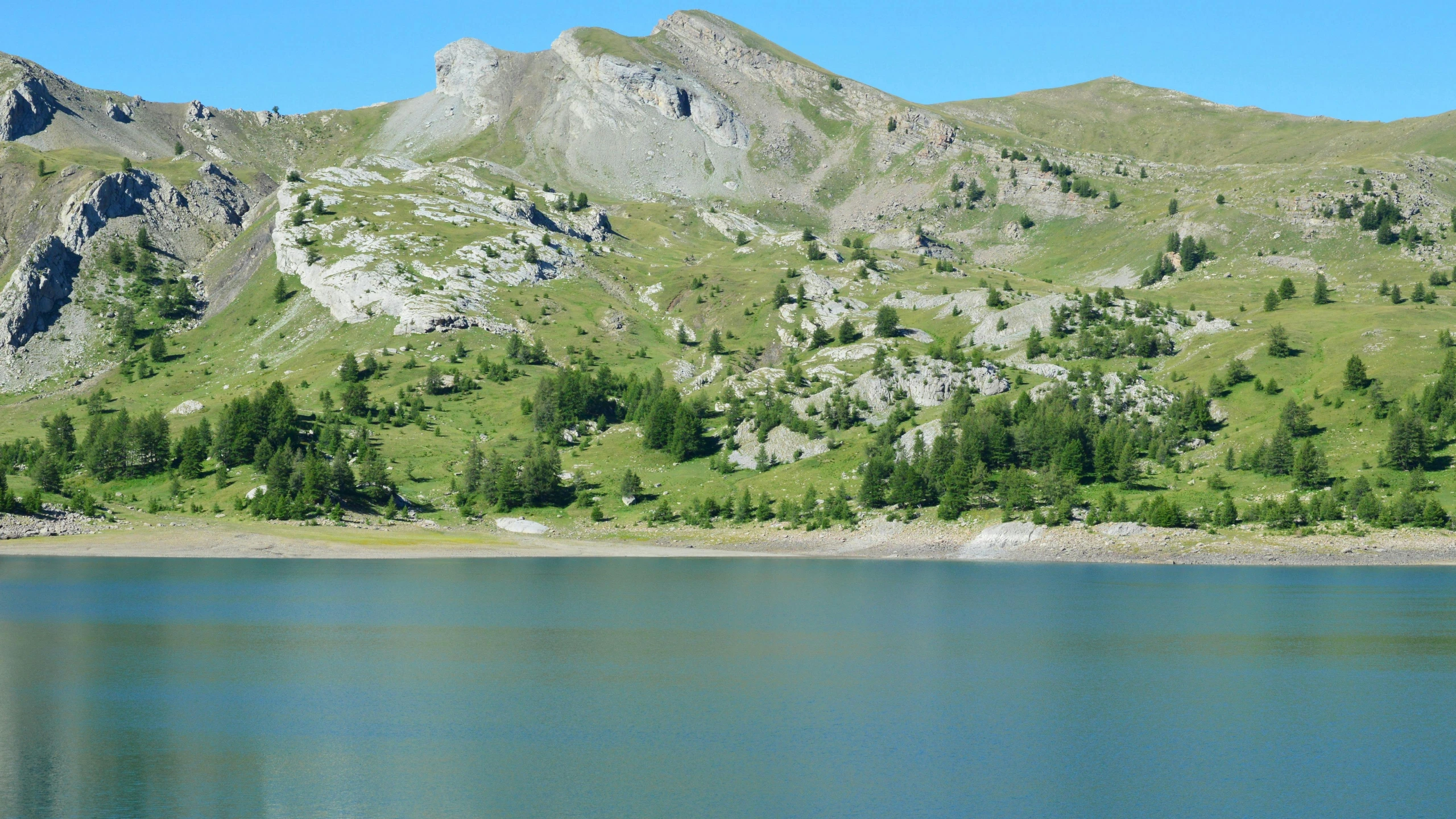 green and leafy mountains rise above water