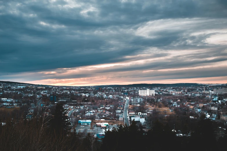 the mountains and city in the distance under a cloudy sky