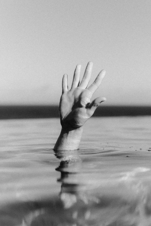 a hand holding out to someone out in the water