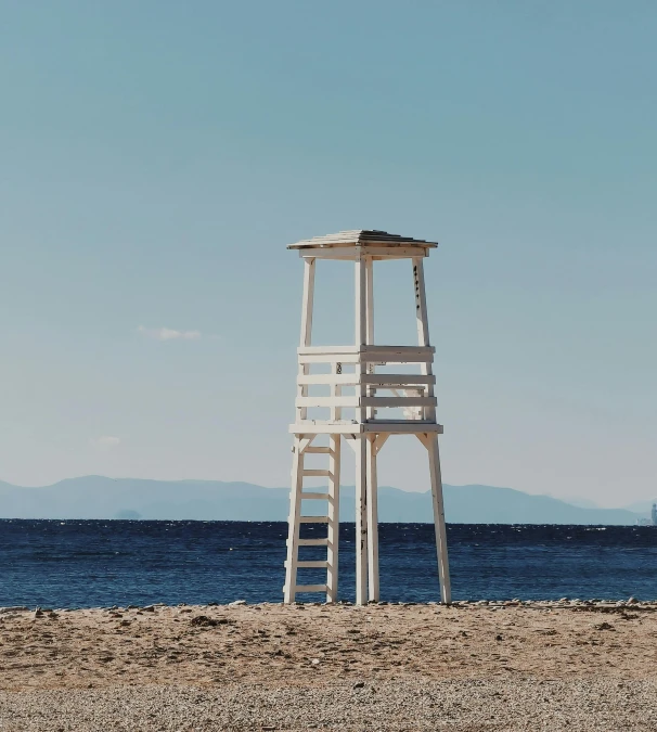 a lifeguard's stand on the beach in front of water