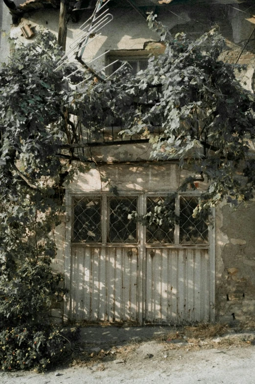 an old doorway with an iron door and a clock on the side